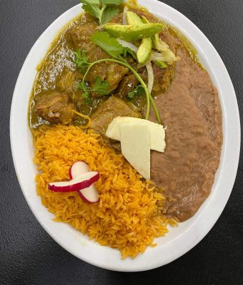 A plate of Mexican food featuring rice, beans, and colorful garnishes.