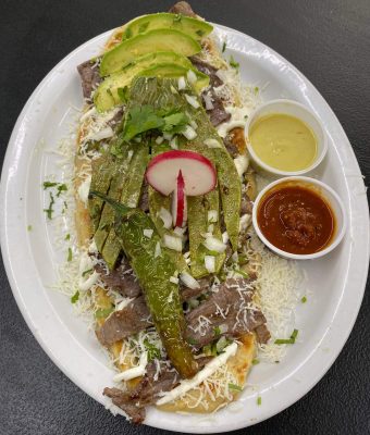 A plate featuring an assortment of meat, cheese, and fresh vegetables arranged artfully.